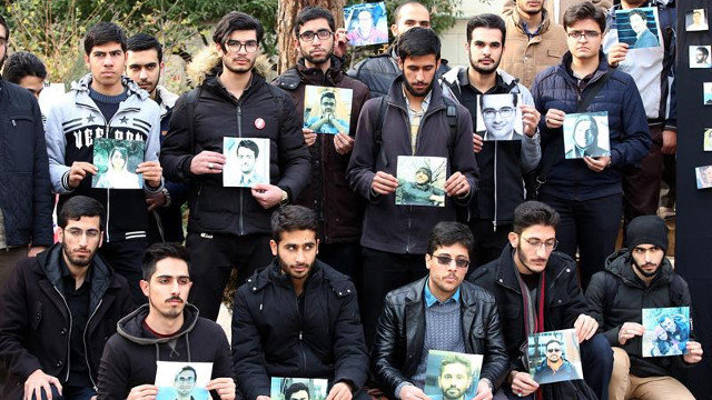 Estudiantes iraníes posan con fotografías de las víctimas del avión derribado por error en Teherán. ABEDIN TAHERKENAREH
