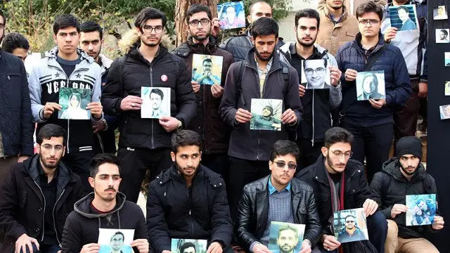 Estudiantes iraníes posan con fotografías de las víctimas del avión derribado por error en Teherán. ABEDIN TAHERKENAREH