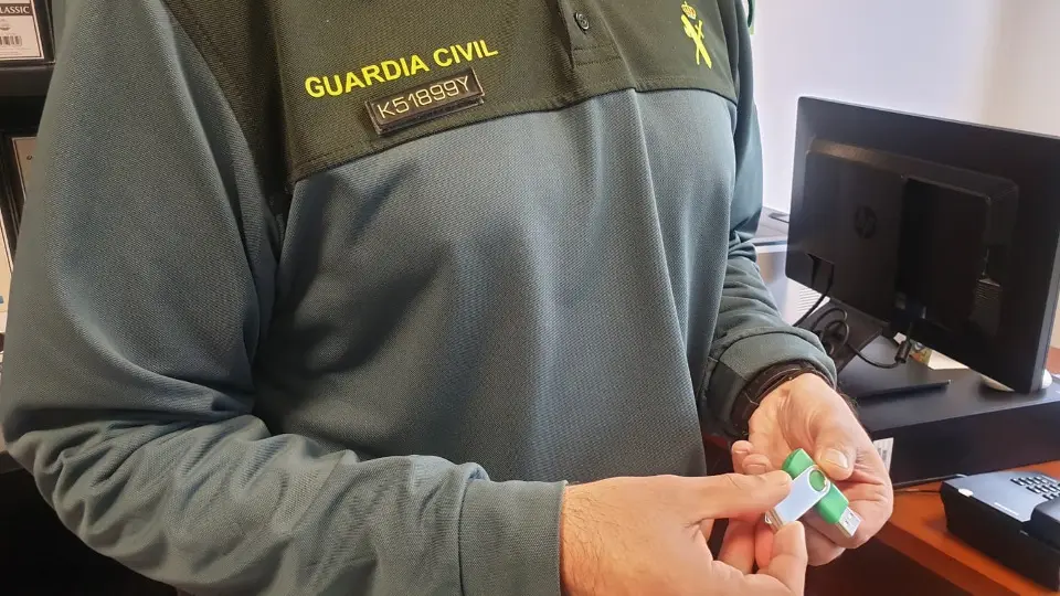 Un agente muestra el pendrive con la obra de la escritora víctima de extorsión. GUARDIA CIVIL