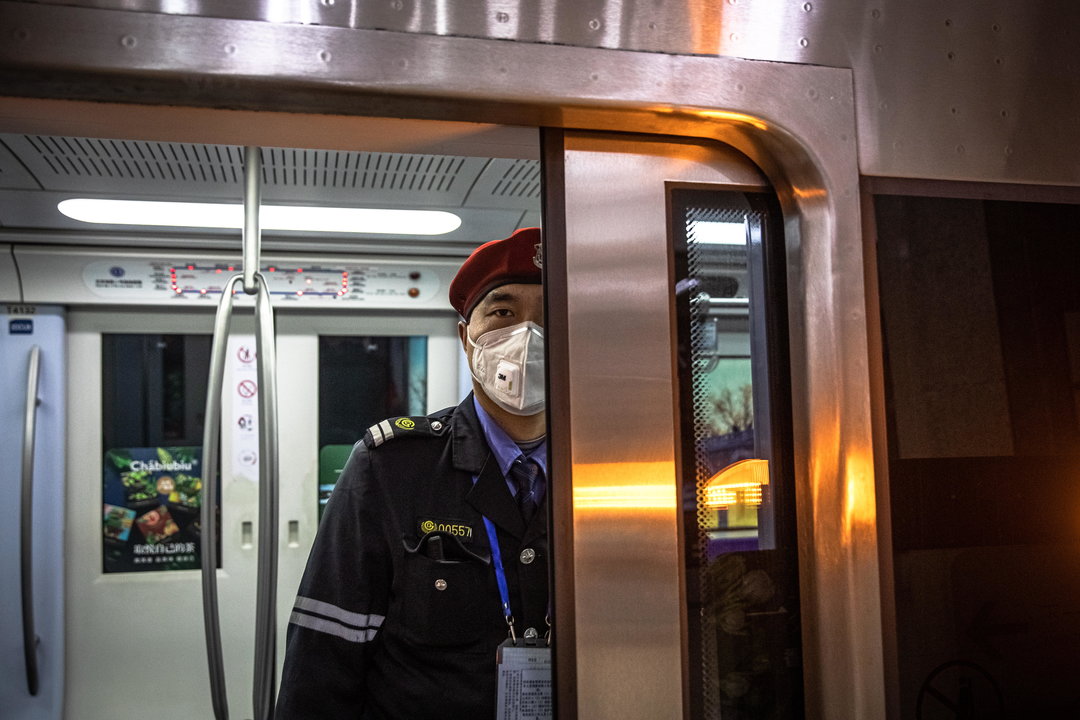 Un empleado del Metro en Beijin, con una mascarilla por el coronavirus. ROMAN PILIPEY