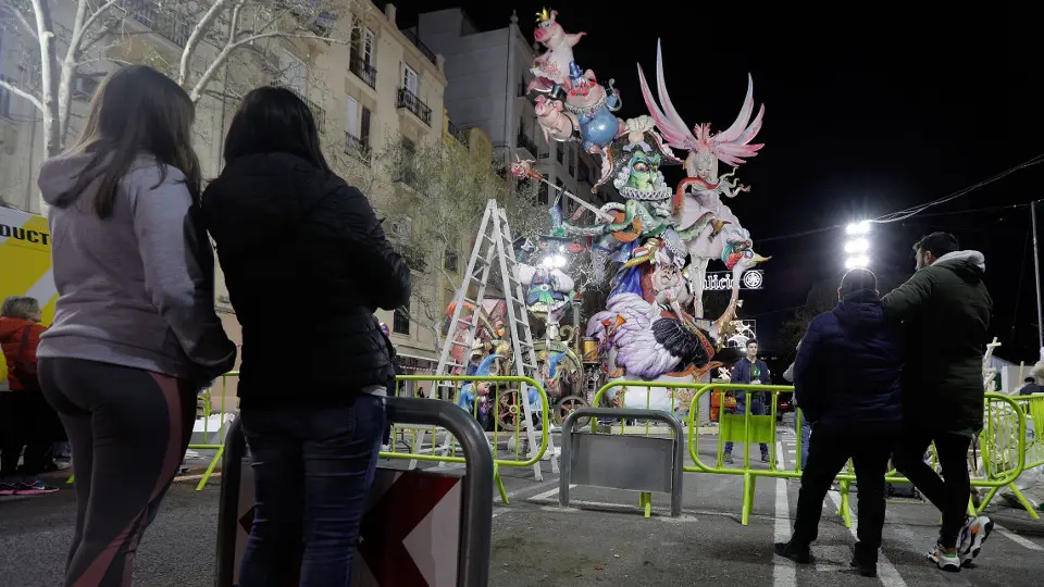 Unos jóvenes observan una falla a medio montar en Valencia. EFE