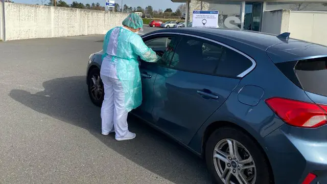 Una técnica del Hula reailza una prueba de detección del coronavirus a un conductor. EP