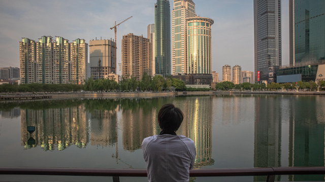 Un hombre contempla frente a un lago los rescacielos de Wuhan.ROMAN PILIPEY (Efe)