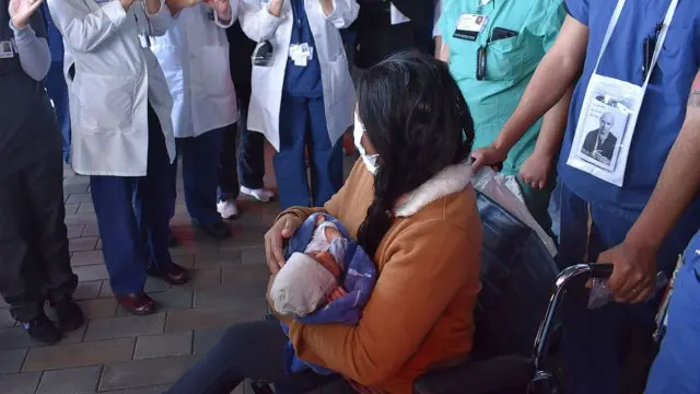 La madre, en silla de ruedas y con su bebé en brazos. YOUTUBE