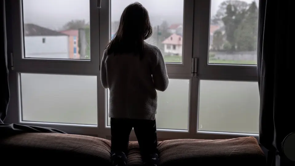 Una niña observa la calle desde su ventana. ELISEO TRIGO (EFE)