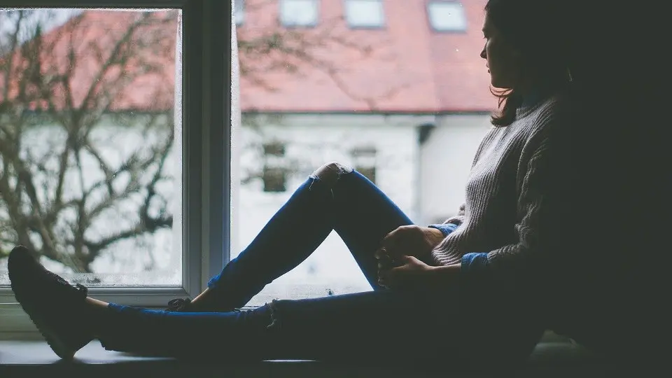 Una joven mira por la ventana. PIXABAY