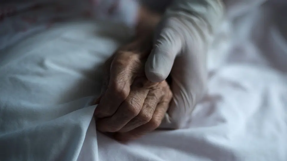 Una trabajadora sujeta la mano de una mujer en una residencia de Celanova. BRAIS LORENZO