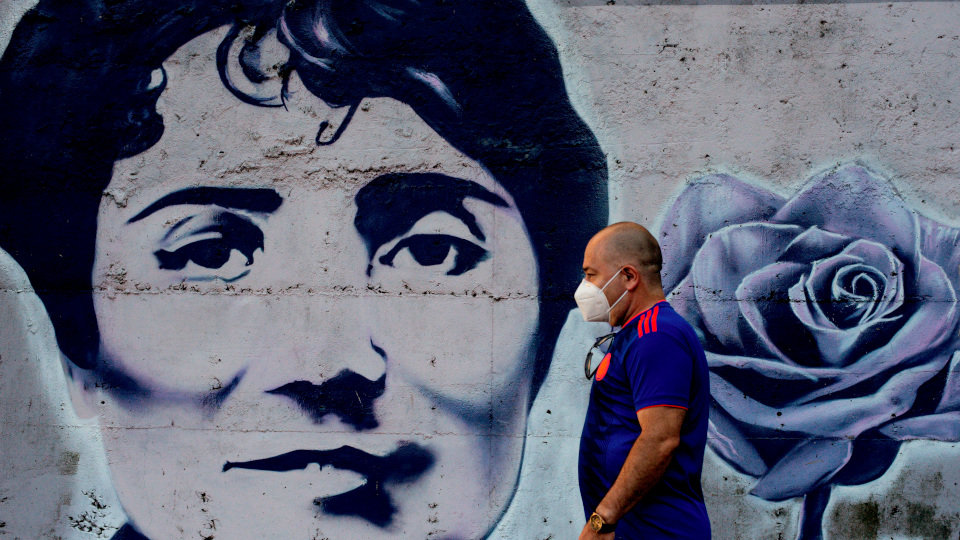 Un hombre con mascarilla pasa ante un mural de Rosalía de Castro en Ourense. BRAIS LORENZO (EFE)