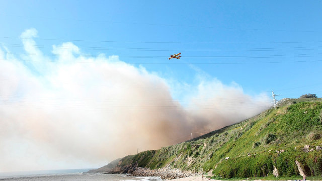 Un avión sofoca las llamas del incendio forestal de A Coruña. CABALAR (Efe)