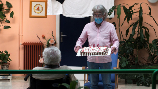 Juan Francisco sostiene una tarta por el cien cumpleaños de su madre Concha, en la residencia de mayores Nuestra Señora de la Esperanza, en Ourense BRAIS LORENZO (Efe)