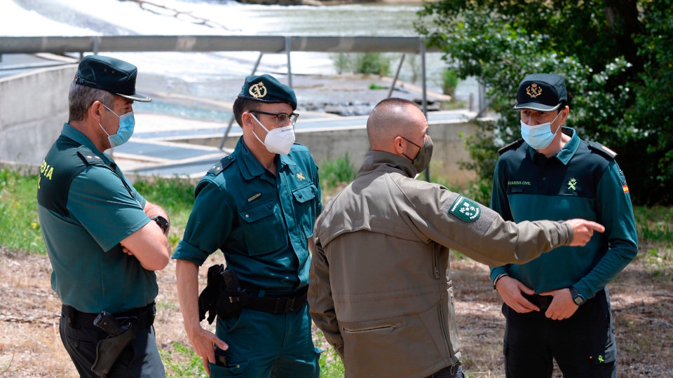 El rastreador de animales Fernando Gómez (2d) conversa con efectivos de la Guardia Civil durante la búsqueda del cocodrilo visto en Valladolid. NACHO GALLEGO (EFE)