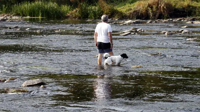 Un home cruza o río Miño durante unha seca. VITORIA RODRÍGUEZ (ARQUIVO)