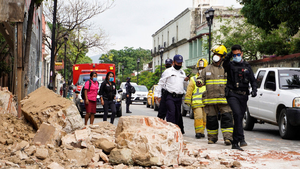 Miembros de la policía y de los bomberos observan los daños causados en la ciudad de Oaxaca por el terremoto. EFE.