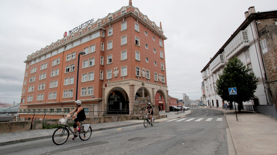 Dos personas circulan en bicicleta por las inmediaciones del hotel de A Coruña donde se encuentra confinado el Fuenlabrada. CABALAR (EFE)