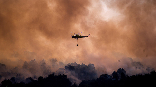 Un helicóptero realiza labores de extinción en el incendio forestal declarado en Cualedro. BRAIS LORENZO