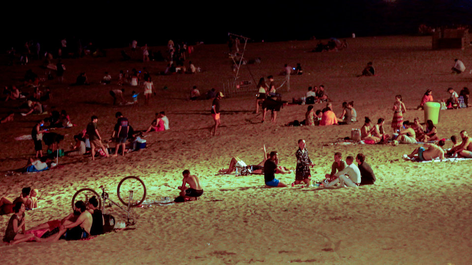 Varios jóvenes se divierten en la playa de la Barceloneta, en Barcelona, tras el cierre de discotecas decretado por las autoridades catalanas. QUIQUE GARCÍA (EFE)