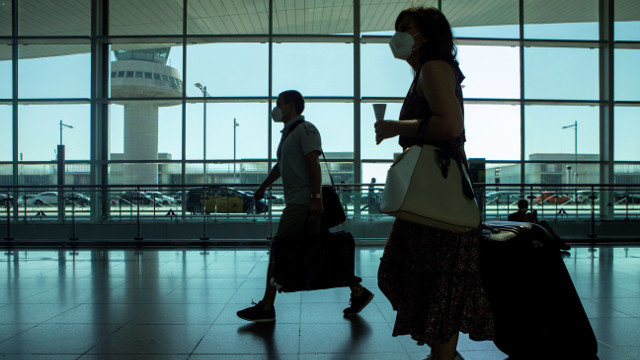 Viajeros con mascarilla en el aeropuerto de El Prat. ENRIC FONTCUBERTA