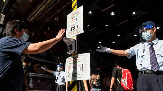 Personas tomándose la temperatura en Hong Kong. EFE