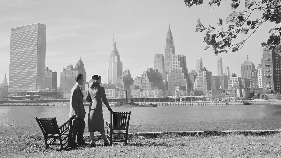 Couple at river by Manhattan skyline , New York City , USA