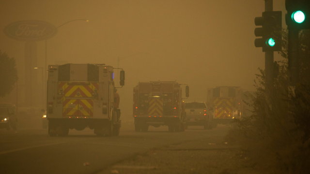 Varios camiones de bomberos avanzan entre el humo en una carretera de Estados Unidos. PETER DASILVA (Efe)