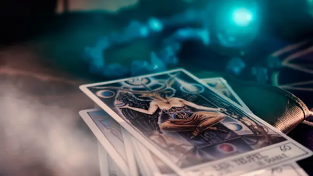 View of tarot card and crystal ball on the table. The Devil. Soft focus. Dark tone.