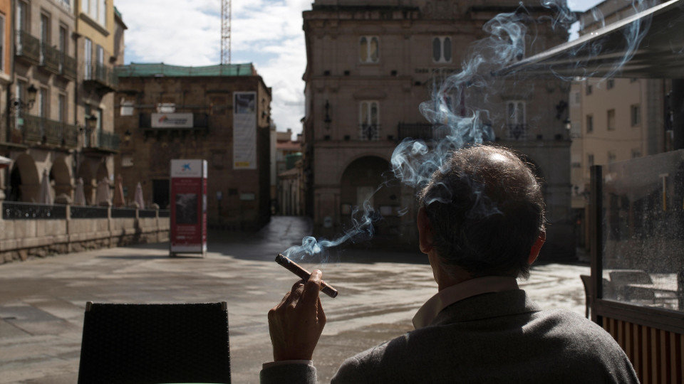 Un hombre fuma sentado en una terraza en la Plaza Mayor de Ourense. EFE