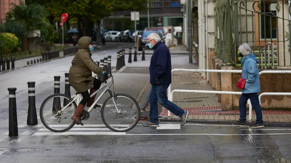 Transe&uacute;ntes caminan por la calle con mascarilla en Pamplona. EFE