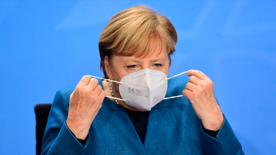 La canciller de Alemania, Angela Merkel, se coloca la mascarilla durante la rueda de prensa de este miércoles. FILIP SINGER (EFE)