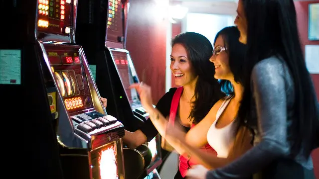 Tres mujeres juegan a una máquina. EFE