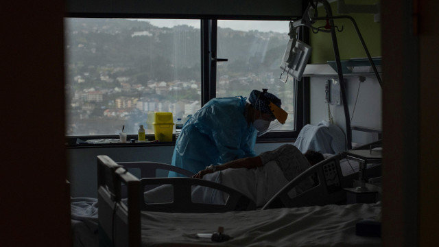 Una trabajadora sanitaria atiende a un paciente con coronavirus en una planta de hospitalización del Complejo Universitario de Ourense. BRAIS LORENZO (EFE)