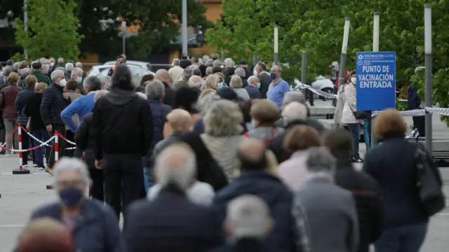 Cientos de personas hacen cola a las puertas de las instalaciones de Ifeco en A Coru&ntilde;a, para ser vacunadas frente al coronavirus. EFE