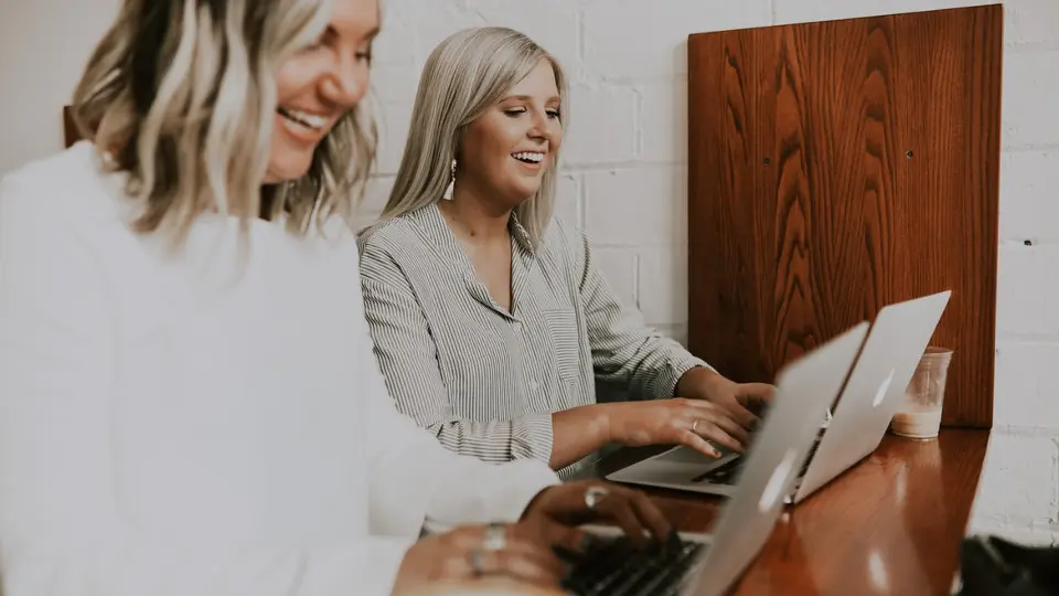 dos chicas escribiendo en ordenadores