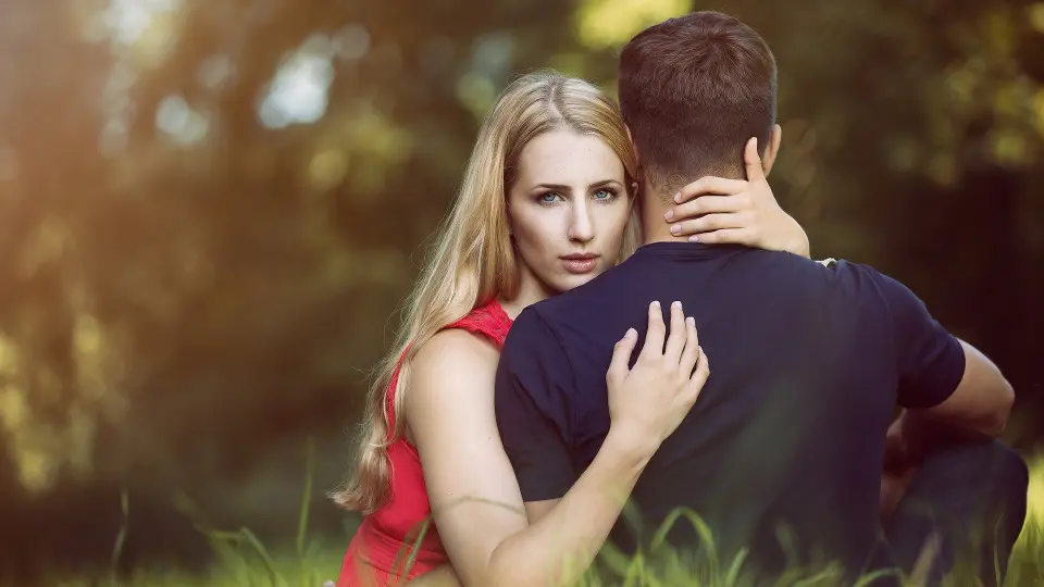 Una pareja abrazada en un campo