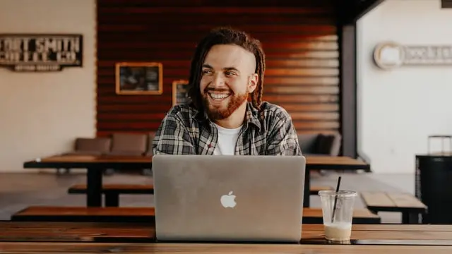 Un chico frente a un ordenador portátil