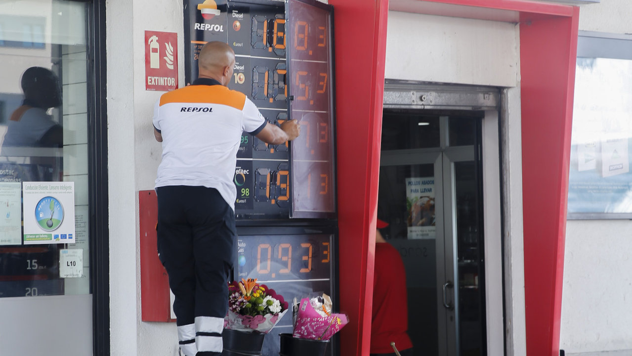 Un trabajador de una gasolinera cambia el panel de precios.EFE