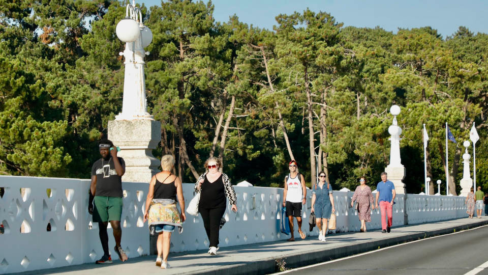 Unos peatones atraviesan el puente que une la isla de A Toxa con el casco urbano de la villa de O Grove. J.L.OUBIÑA