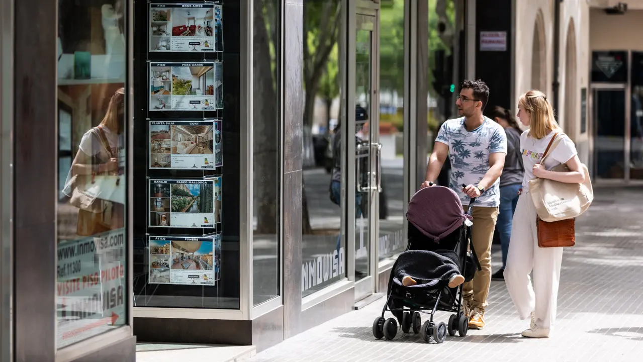 Una pareja pasa ante una inmobiliaria. EUROPA PRESS