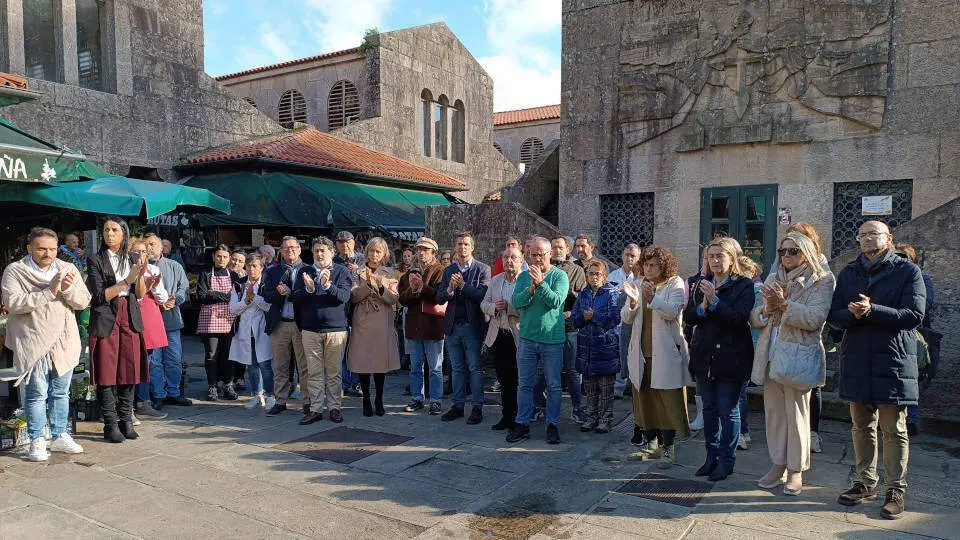 Aplausos tras el minuto de silencio por la muerte violenta de Antonio Costa en la Praza de Abastos de Santiago. V.M.R.