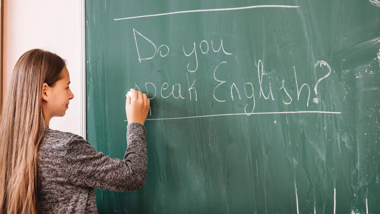 Una mujer escribe en una pizarra.Freepik