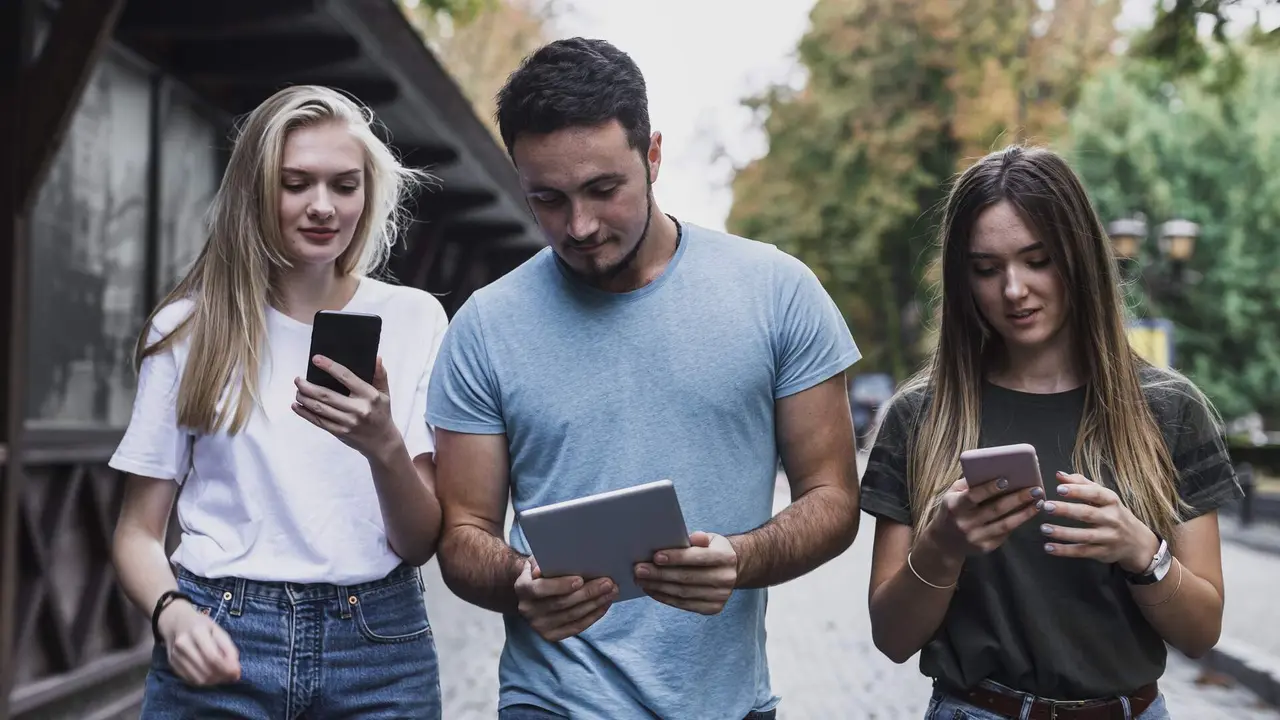 Varios j&oacute;venes revisan sus dispositivos. FREEPIK
