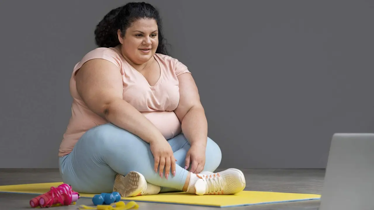 Una mujer con sobrepeso realiza ejercicio. FREEPICK