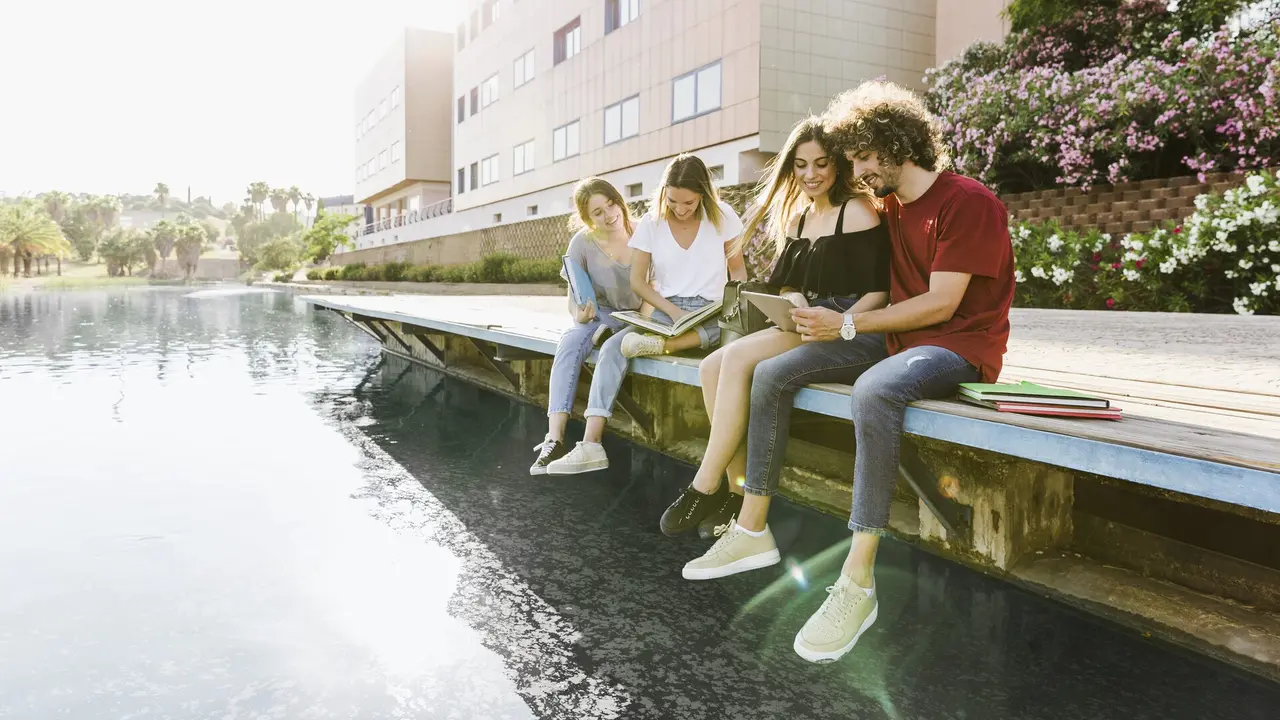 Alumnos jóvenes ojean unos libros en el extranjero. FREEPICK