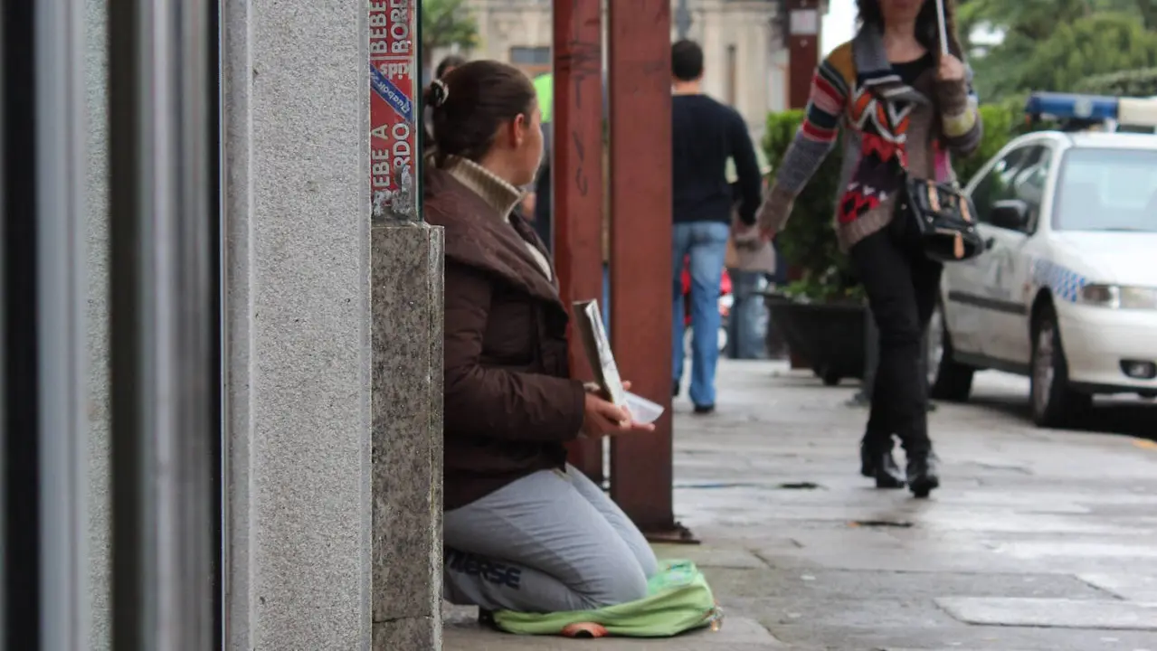 Una mujer pide una ayuda en una calle de Lugo. AEP