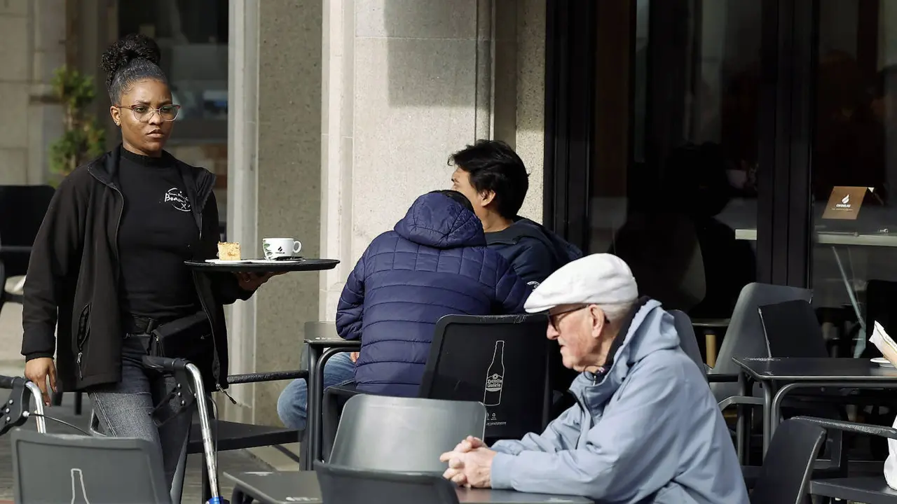 Una camarera atendiendo una terraza en Burela. J.M. ALVEZ