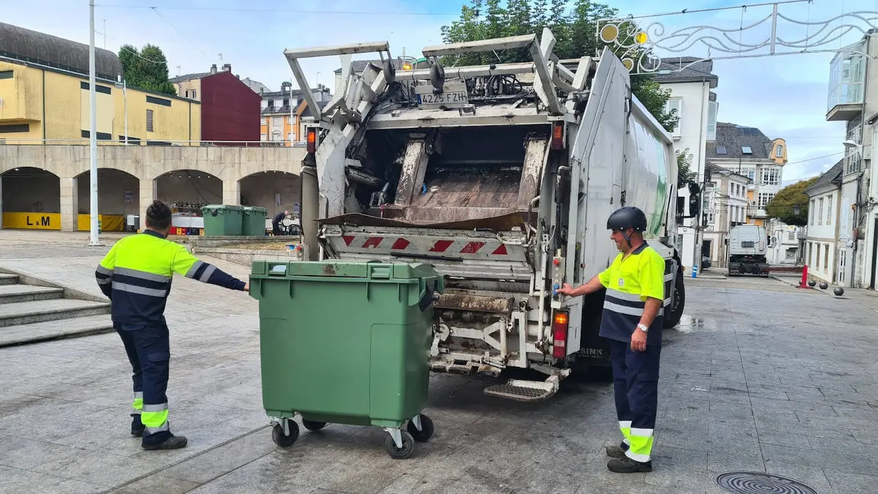 Dos operarios recogen la basura en Vilalba en foto de archivo. AEP