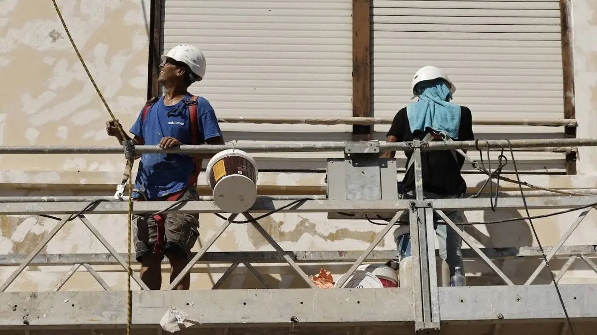 Dos trabajadores extranjeros, en un andamio. AEP