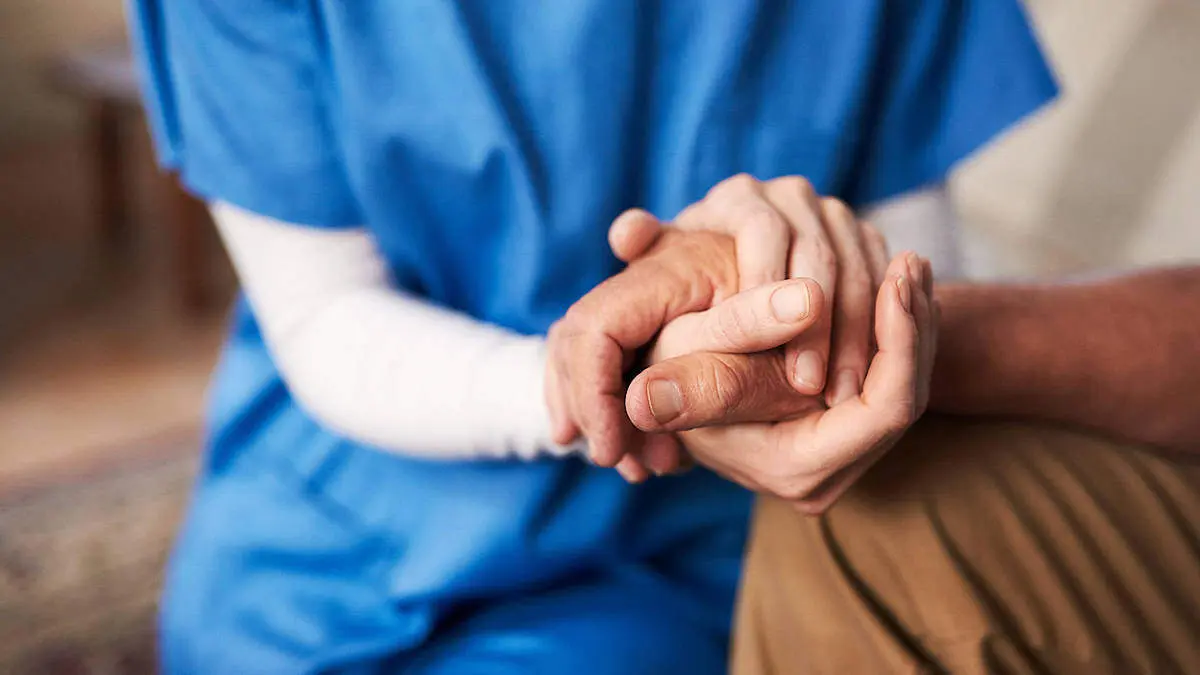 Una profesional atiende a una persona con dependencia. EP