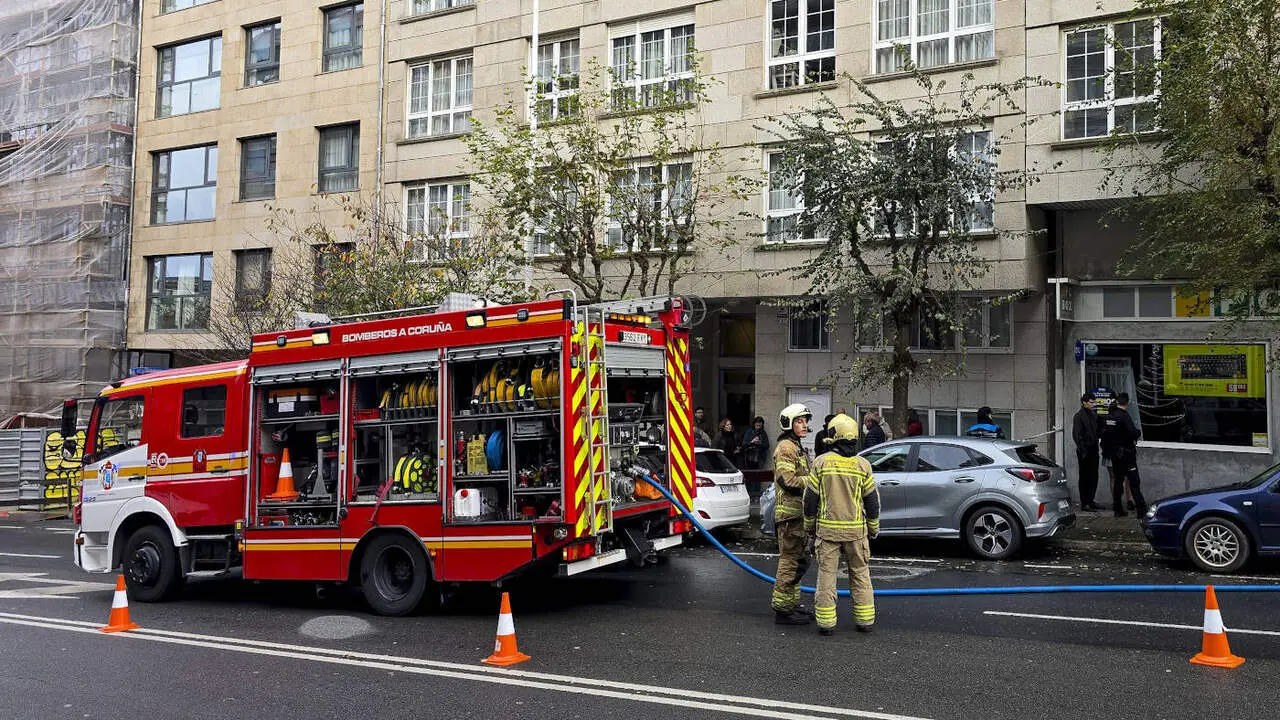 Polic&iacute;as y bomberos ante el edificio del Paseo da Ronda de A Coru&ntilde;a donde el joven apu&ntilde;al&oacute; mortalmente a su compa&ntilde;era de piso. EFE