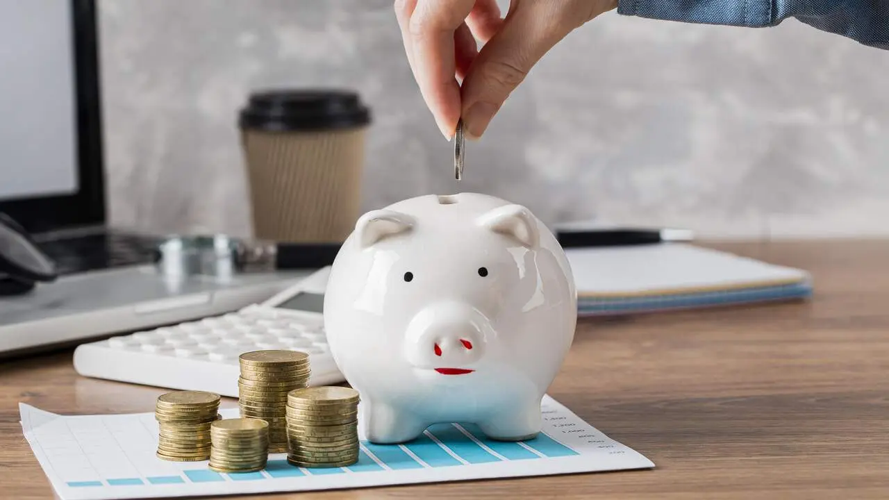 Monedas y una hucha. FREEPIK