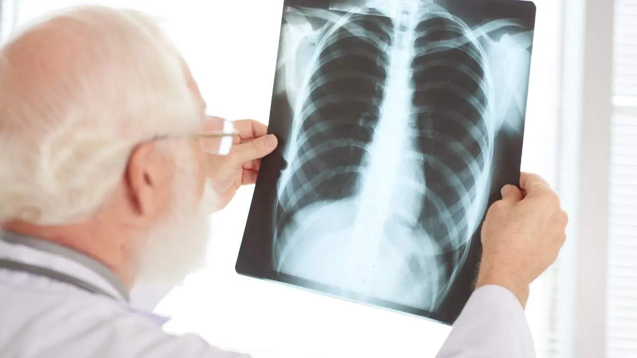 Over the shoulder view of senior doctor examining chest x-ray image